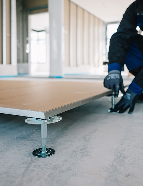 Hände mit Arbeitshandschuhen bei der Verlegung eines Bodens