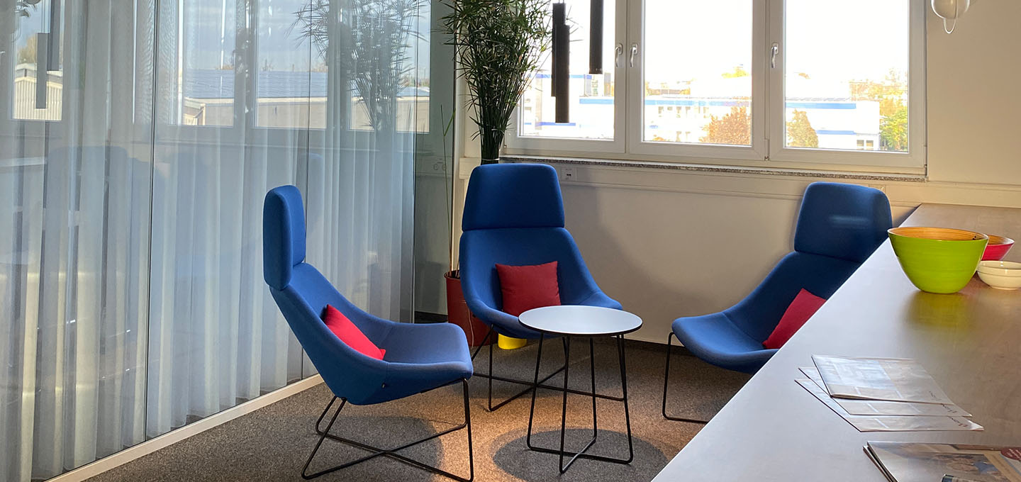 Drei blaue Stühle mit roten Kissen