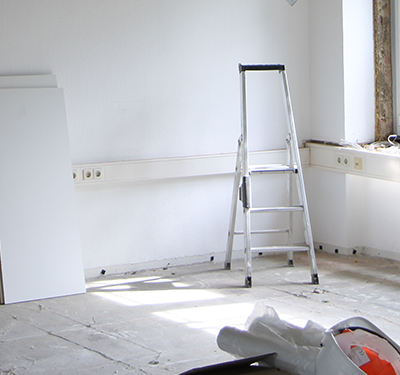 Ecke eines Raums mit Gipskarton-Platten und Leiter